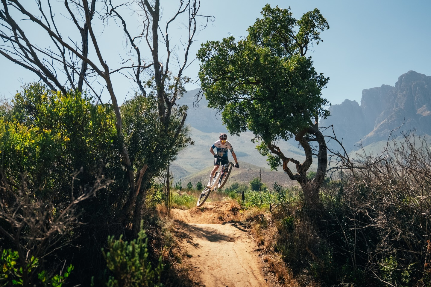 Radsportlerin auf einem Trail in einer Berglandschaft