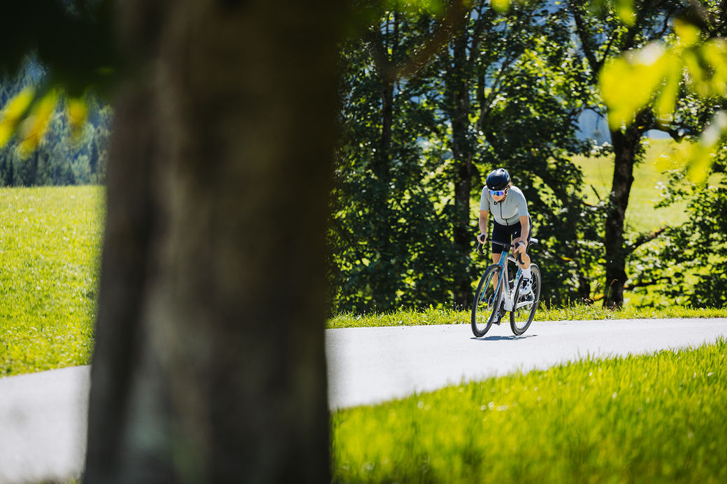 Rennradfahrerin mit MERIDA SCULTURA auf einer Straße im Grünen
