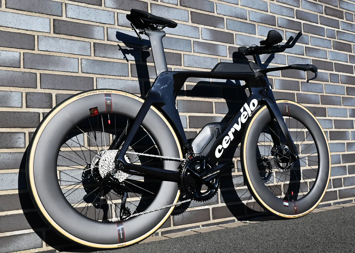 Cervélo P5 Triathlonrad mit tiefen Laufrädern vor einer Ziegelwand